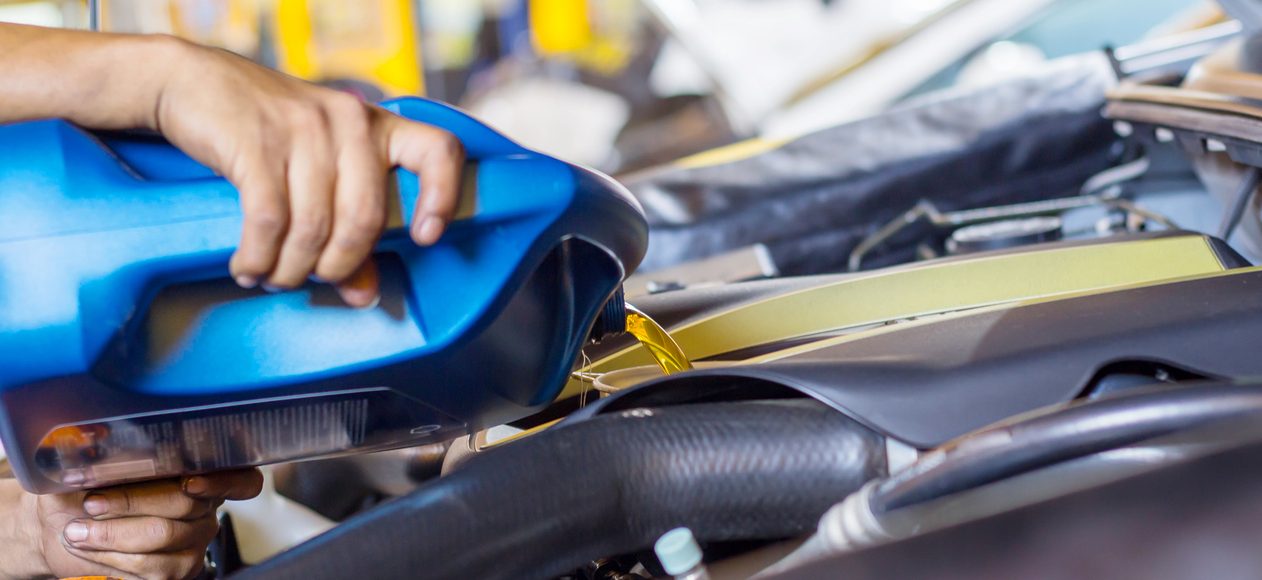 Pouring oil into car engine