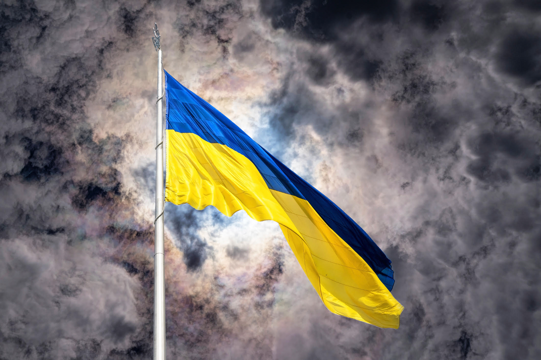majestic high banner and the state blue-and-yellow flag of ukraine, waving against the background of a purple sunset stormy sky. Celebration of the Independence Day of Ukraine, August 24. The concept of danger, armed conflict in Ukraine, patriotism and courage